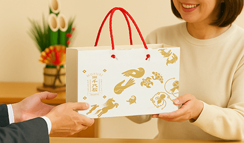 おせんべいのギフトをお渡ししている